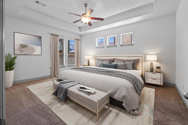 Carpeted bedroom featuring baseboards, visible vents, a raised ceiling, and ceiling fan | Image 12