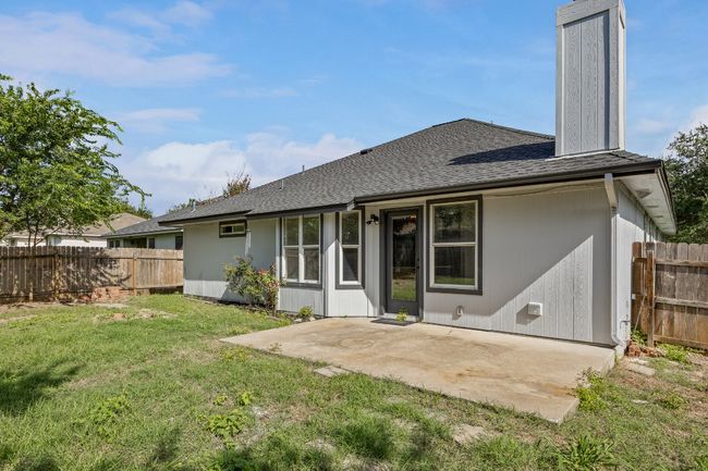 Back of house featuring roof with shingles, a patio, and a chimney | Image 21
