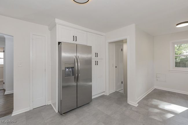 Kitchen featuring light tile patterned floors, stainless steel fridge, and white cabinets | Image 18