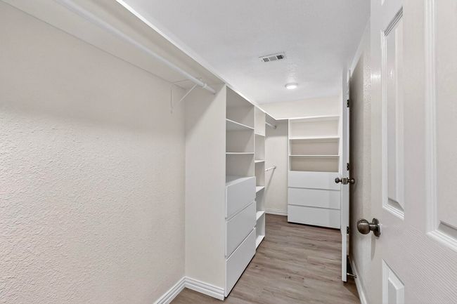 Spacious closet with wood finished floors | Image 8