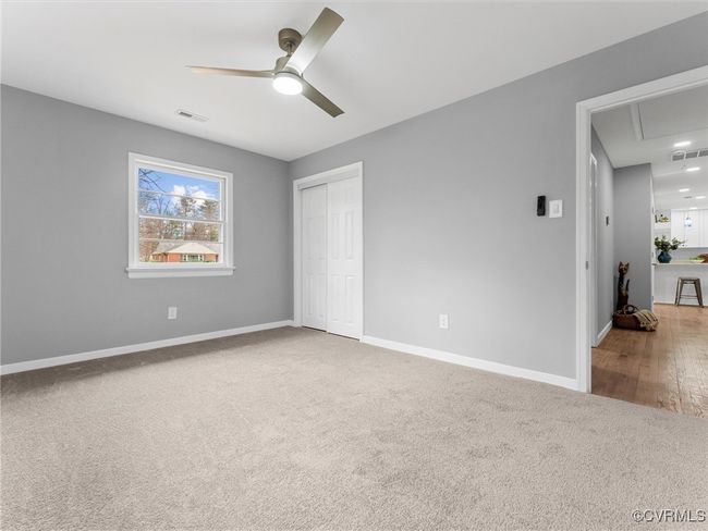 Unfurnished bedroom with attic access, carpet, visible vents, and baseboards | Image 28