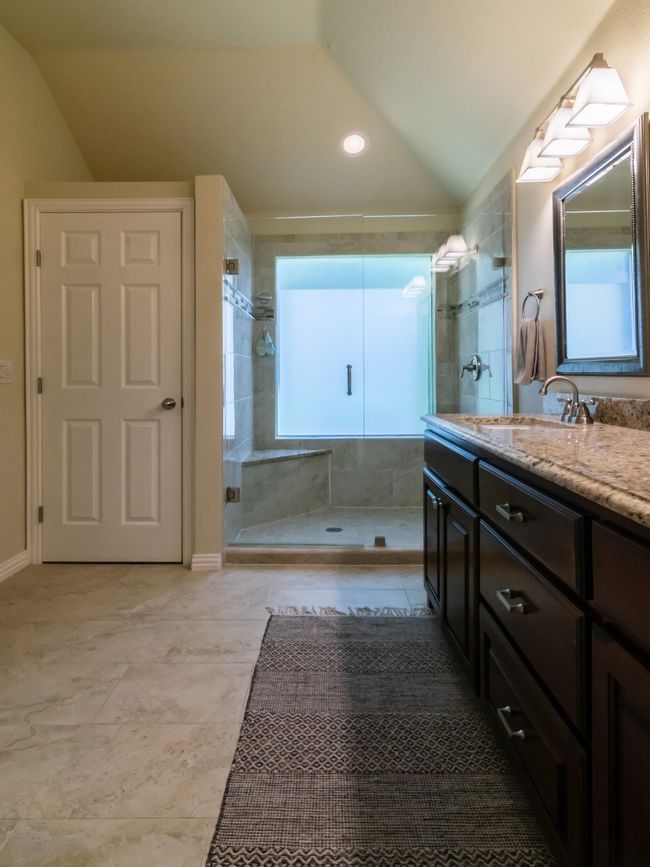 Bathroom featuring vaulted ceiling, double vanity, and a shower stall | Image 23