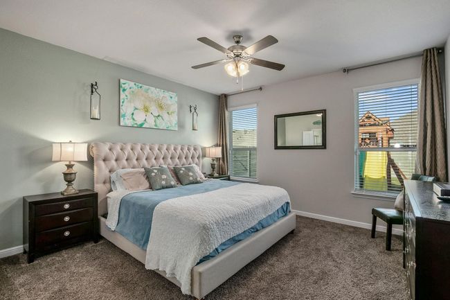 Carpeted bedroom with baseboards, multiple windows, and a ceiling fan | Image 10