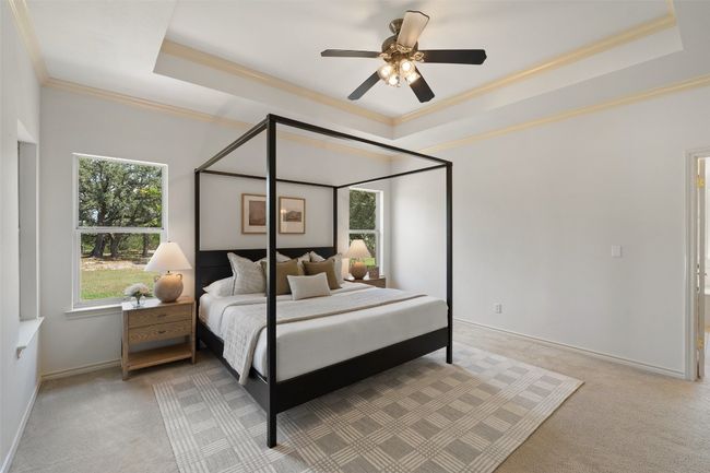 The private primary suite is a true retreat, complete with direct access to the back patio, serene backyard views, and a generously sized en suite bathroom featuring a garden tub, separate shower, dual-sink vanity, and walk-in closet. | Image 15