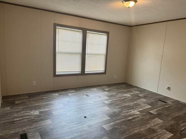 Empty room with visible vents, a textured ceiling, and dark wood-type flooring | Image 10