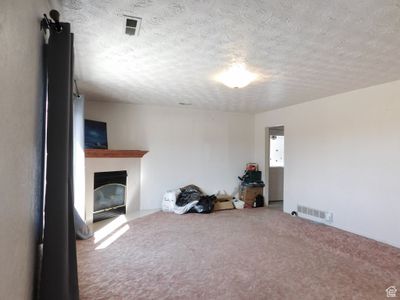 There are natural wood floors under the carpet in this room. | Image 2