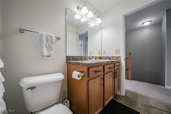 Bathroom featuring tile patterned flooring, toilet, vanity, and a textured ceiling | Image 14