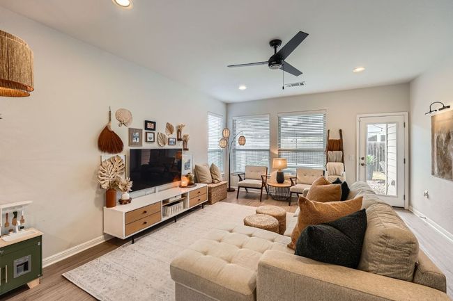 Living area featuring visible vents, lighting, a ceiling fan, and wood finished floors | Image 4