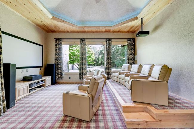 The media room has eight reclining chairs, a projector, and plush printed carpet. | Image 36
