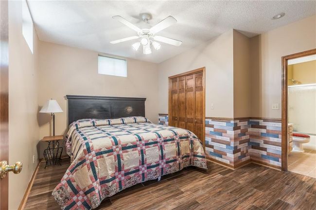 Bedroom with a ceiling fan, a closet, connected bathroom, and wood finished floors | Image 63