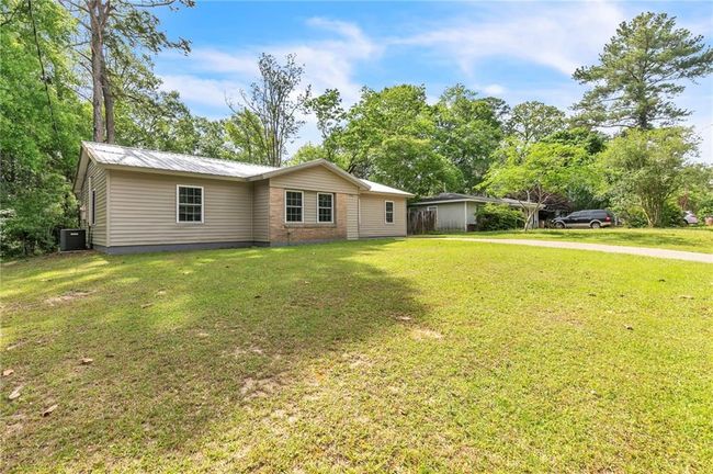 View of front of home with a front yard, central air condition unit, and metal roof | Image 4