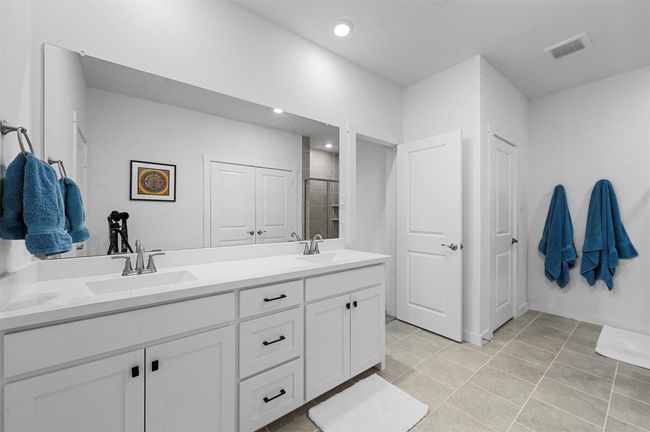 Bathroom with tile patterned floors, vanity, and a shower with door | Image 22