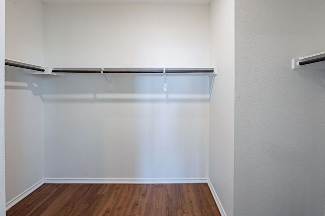 Spacious closet with wood finished floors | Image 11