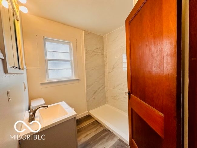 bathroom with vanity, tiled shower, and wood finished floors | Image 17