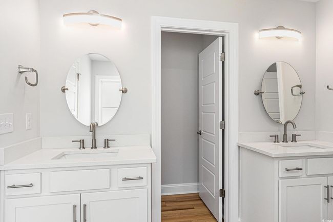 Full bathroom with two vanities and wood finished floors | Image 18