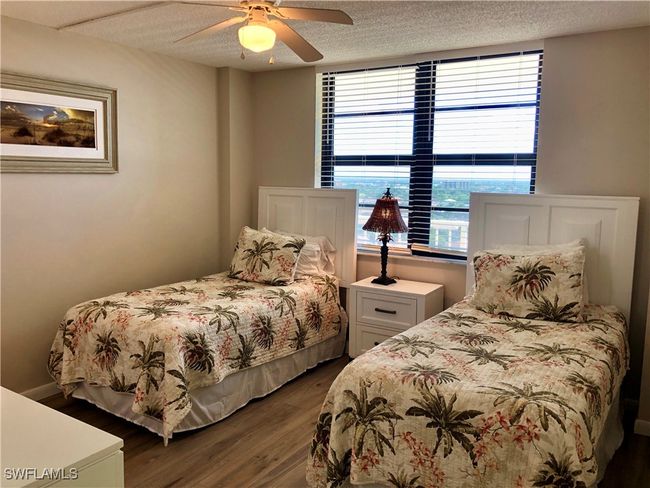 Bedroom with a textured ceiling, ceiling fan, and dark wood-style flooring | Image 16
