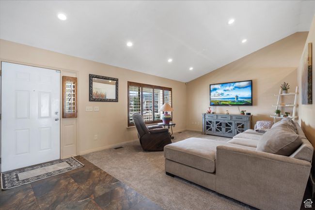 Carpeted living room with baseboards, lofted ceiling, visible vents, and recessed lighting | Image 8