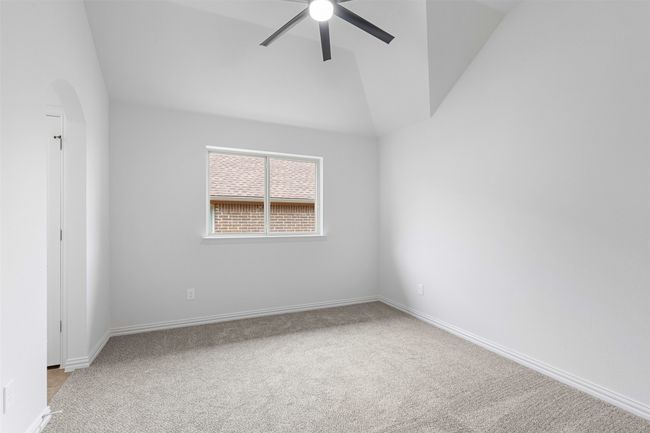 Spare room with arched walkways, light colored carpet, baseboards, a ceiling fan, and lofted ceiling | Image 30