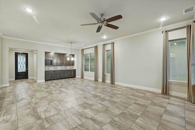 Living Room- Dining Room combination with tile floors, crown molding, ceiling fan and built in buffet. | Image 6