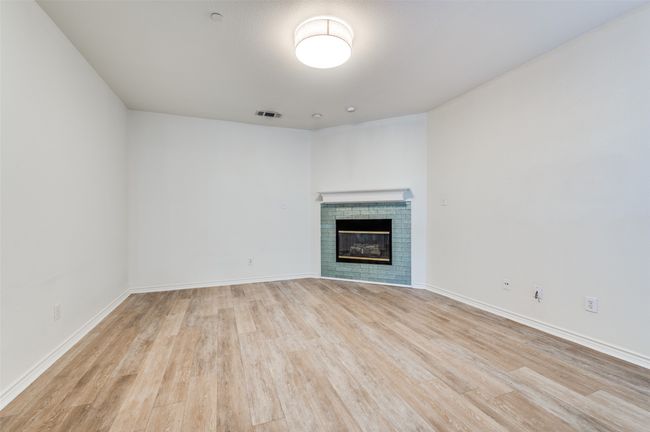 Unfurnished living room featuring light wood-type flooring and a fireplace | Image 6