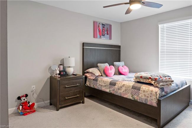 Bedroom featuring baseboards, light colored carpet, and ceiling fan | Image 30