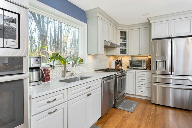 Picture window allows an abundance of natural light. Marble backsplash compliments the Silestone countertops and island. | Image 6