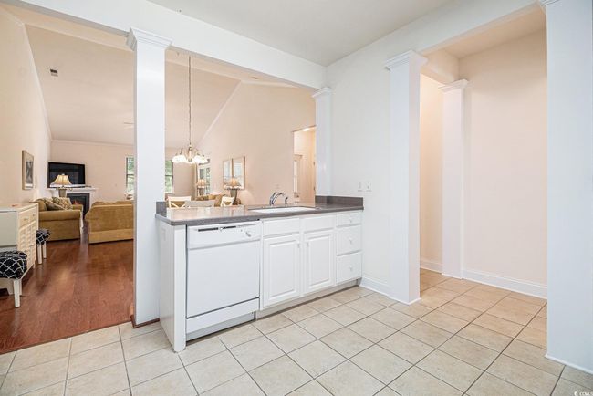 Kitchen with dishwasher, a sink, vaulted ceiling, light tile patterned flooring, and a chandelier | Image 12