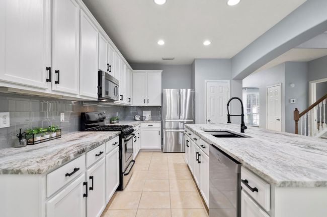 A closer look at the kitchen reveals the upgraded sink, faucet, and hardware—paired with generous prep space and plenty of storage. | Image 13