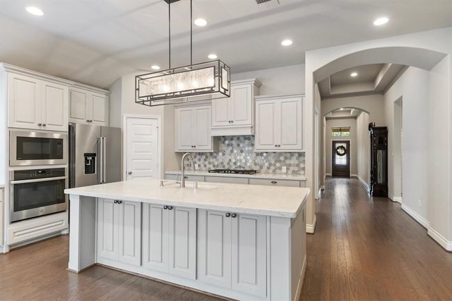 Kitchen Boasts Island with Breakfast Bar and Cabinets for Storage. | Image 8