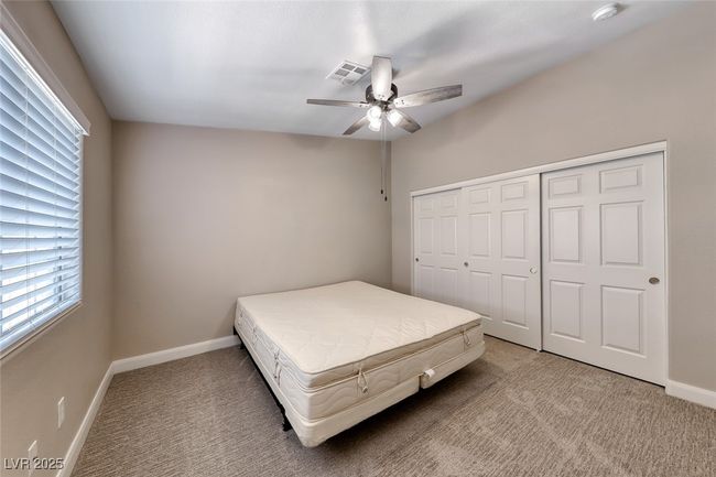Bedroom with light colored carpet, a ceiling fan, and a closet | Image 24