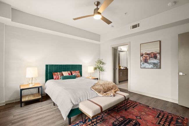 Bedroom featuring wood finished floors, baseboards, ensuite bath, and ceiling fan | Image 16