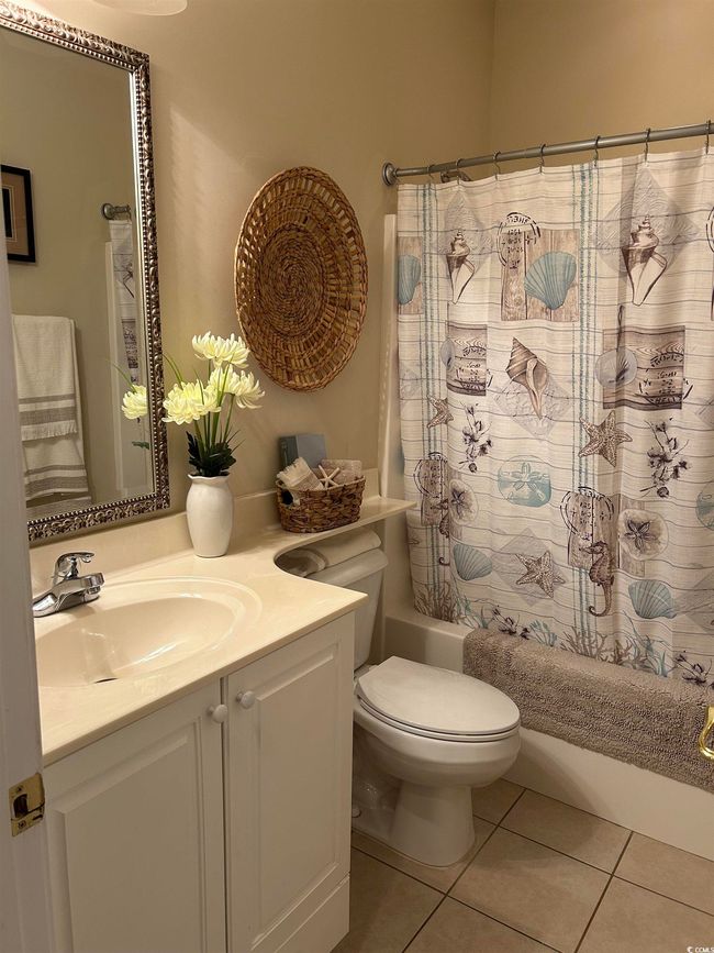 Bathroom featuring toilet, shower / bathtub combination with curtain, vanity, and tile patterned floors | Image 14