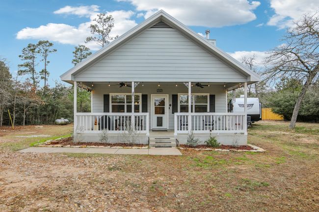 Bungalow-style home featuring ceiling fan, covered porch, and a front lawn | Image 9