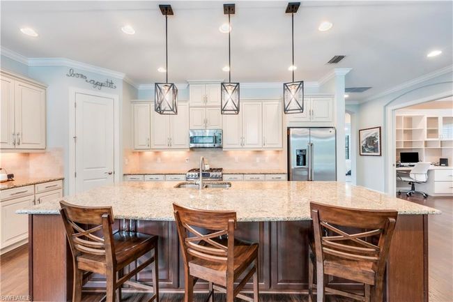 Kitchen with stainless steel appliances, a spacious island, backsplash, hanging light fixtures, and recessed lighting | Image 10