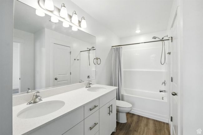 Full bath featuring shower / bath combo, double vanity, and wood finished floors | Image 20