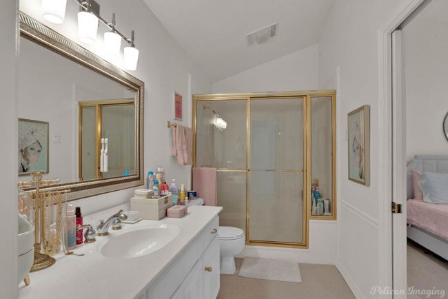Ensuite bathroom with toilet, visible vents, a shower stall, vanity, and vaulted ceiling | Image 22