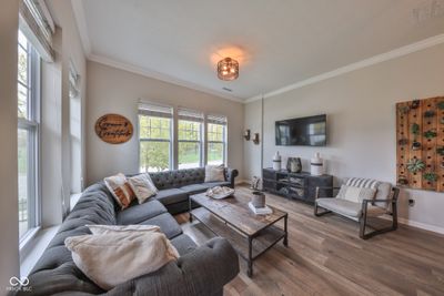 Sizeable family room with soft, neutral tones and sunlight streaming in creating a cozy & comfortable atmosphere. | Image 3