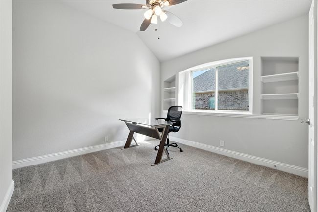 Carpeted office space with lofted ceiling, ceiling fan, and built in features | Image 26