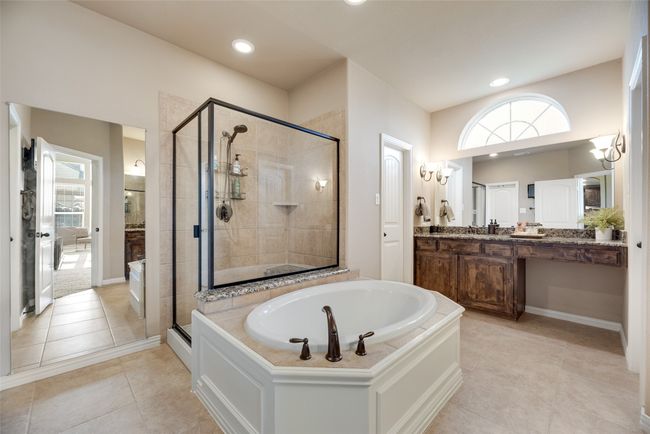 Bathroom with a bath, a stall shower, vanity, tile patterned flooring, and recessed lighting | Image 16