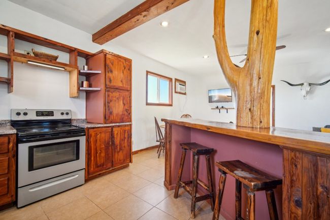 Kitchen bar with stools tucked under. | Image 8
