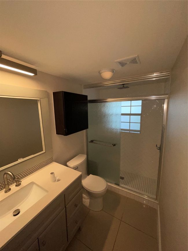 Bathroom with vanity, a shower stall, tile patterned flooring, and toilet | Image 15