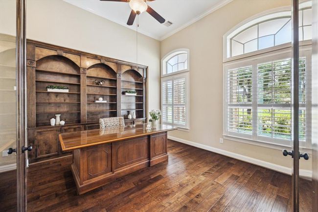 An elegant private study with glass French doors, custom built ins, plantation shutters and tons of natural light | Image 12