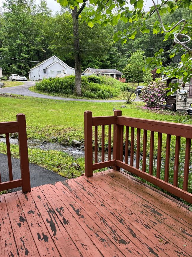 Wooden terrace featuring a lawn and a forest view | Image 5
