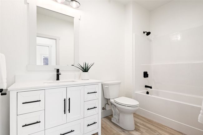Bathroom featuring vanity, wood finished floors, and washtub / shower combination | Image 30