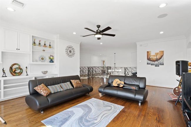 Spacious secondary living area on the second floor, designed for multi-generational living. Built-in storage, a ceiling fan, and a wall of windows provide both comfort and natural light. | Image 28