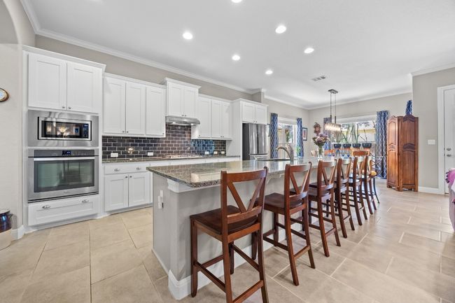 Granite countertops, tile backsplash, and shaker-style cabinets bring the perfect mix of style and substance | Image 15