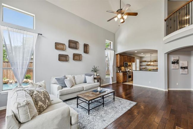 Living room with high vaulted ceiling, plenty of natural light, and dark wood-type flooring | Image 12