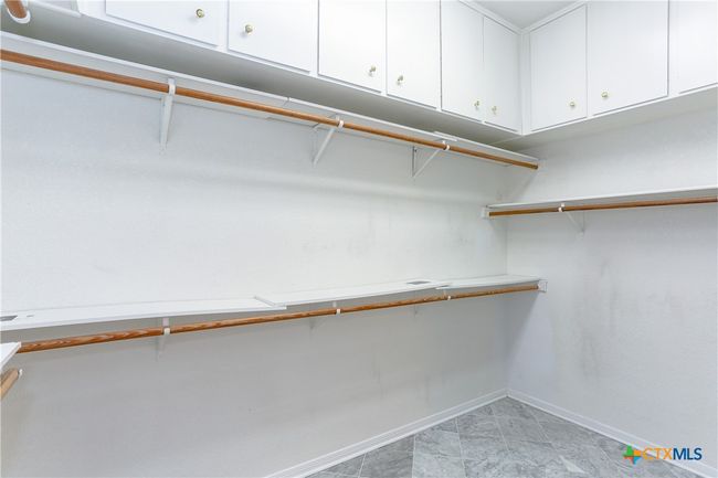 Primary bedroom walk in closet with cabinets for storage Dimensions 9ft X 12ft. | Image 21