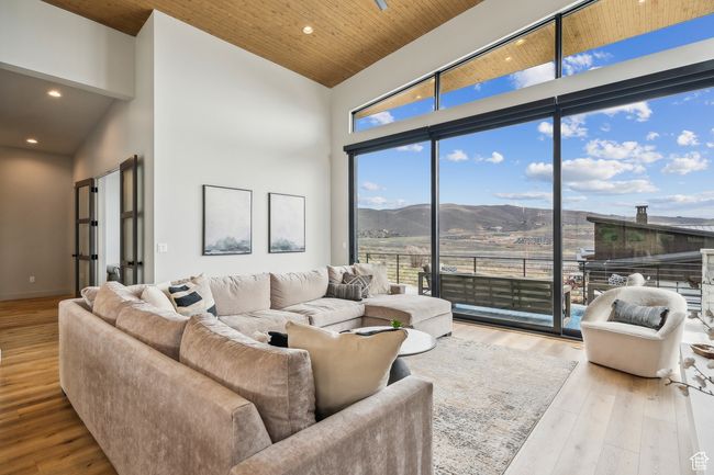 Living room with wood finished floors, high vaulted ceiling, recessed lighting, and a mountain view | Image 23