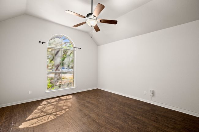 Spare room with lofted ceiling, dark wood-style flooring, and a ceiling fan | Image 23